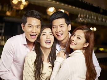 young asian friends couples enjoying party in pub.