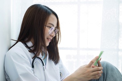 female doctors sitting sit play phone enjoy the pleasure of using a smartphone device during their leisure time in the hospital.