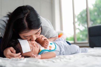 sick asian baby lying on the bed with a cool jell at head for reducing temperature.