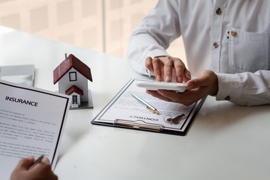 buying a home or insurance, an insurance agent explains the lease agreement to a client before making a contract. mortgage loan approval home loan and insurance concept.

