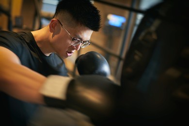 asian man kickboxing in a training gym