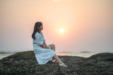 asian women on the rocks by the sea