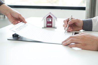 real estate agents offer sale home insurance and close the sale immediately after the customer signs a purchase contract under a formal agreement. real estate home insurance concept.