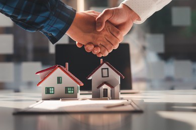 the real estate agent is explaining the house style to the clients who come to contact to see the house design and the purchase agreement, mortgage loan approval home loan and insurance concept.