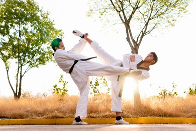 two taekwondo kickers kicking each other simultaneously