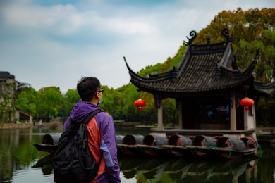 A backpacker looking at the pavillion on the lake