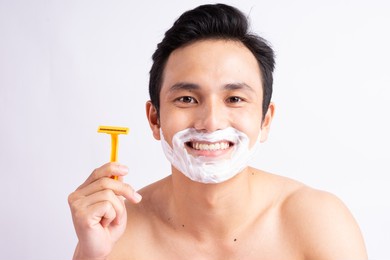 portrait of asian man shaving
