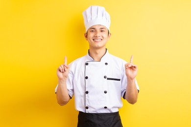 image of asian male chef on yellow background
