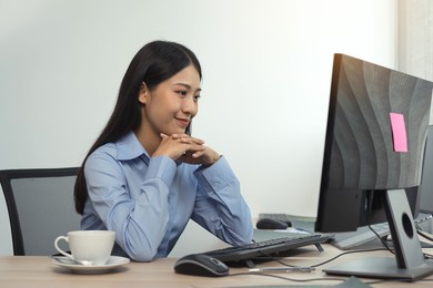 asian woman software developers sitting in front of computers looking at computer codes on the screen.