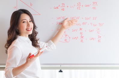 the asian female teacher is rewriting the lecture on the board
