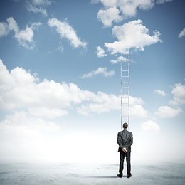 rear view of businessman standing near ladder going high in sky