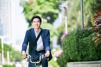 young asian business executive commuting by bike happy and smiling
