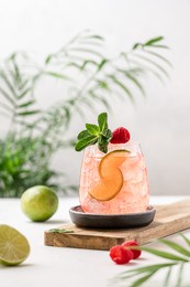 raspberry lemonade with lime. refreshing soft drink in glass. white summer background