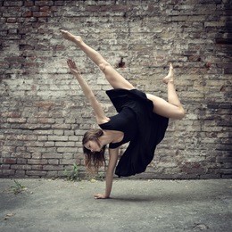 attractive teen girl dancing outdoor against grunge bricks wall. toned.