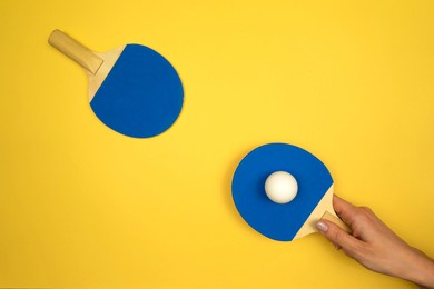 two blue table tennis rackets lie on a yellow table ready for the tournament