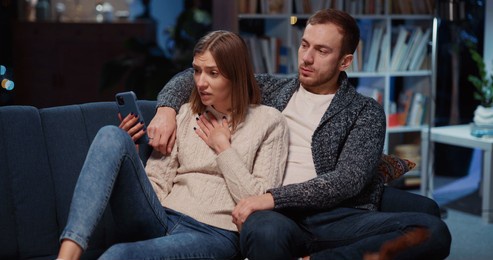 caucasian couple of wife and husband communicasting online on mobile phone videocall. unhappy young woman learning bad news talking webcam wirh family.
