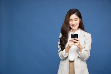 cheerful asian businesswoman using smartphone and receiving good news from the message on mobile chat application over white background