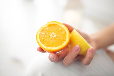 yellow lemon in the girl's hand. summer is coming. the tropical fruits and hands of the girl announce summer. summer fruits. lemon like the sun.