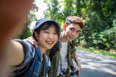 asian group of young people with friends and backpacks walking together and happy friends are taking photo and selfie ,relax time on holiday concept travel