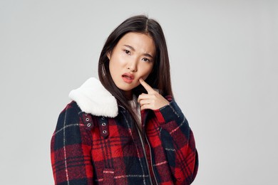 asian woman in winter jacket plaid fabric model light background