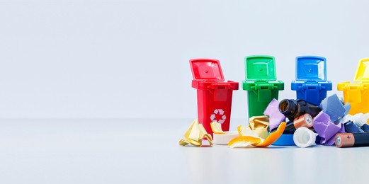waste recycling concept. plastic containers for garbage of different types and different trash on grey background with copy space. banner.
