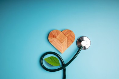 health care, harmony and organic healthy lifestyle concept. living and close to nature. wooden jigsaw as heart shape with stethoscope and leaf. look like flower plant. growth of love and relationship