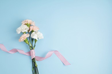 bouquet of pink carnation flowers over blue background. saint valentine, mothers day idea
