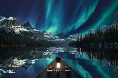 canoeing with aurora borealis over mountain range in maligne lake at jasper national park, canada. fine art concept