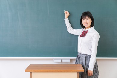 beautiful young asian school girl,blackboard