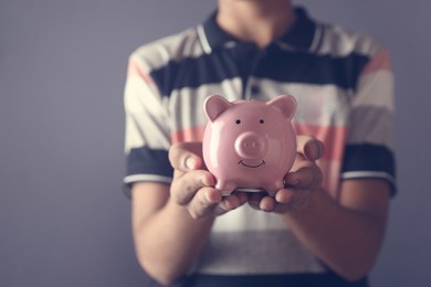 portrait of indian boy holding piggy bank for saving money