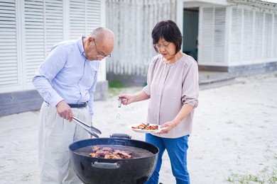 active senior having outdoor barbecue