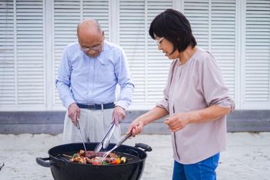 active senior having outdoor barbecue