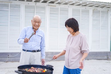 active senior having outdoor barbecue
