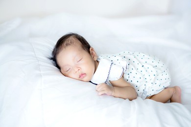 close up adorable asian 3 months years old baby girl sleeping on white bed , newborn peace sleeping concept