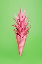 summer composition with ice cream cone and pink painted pineapple leaves against neon green background. creative abstract sweet food concept.  fruit and candy pop art aesthetic.