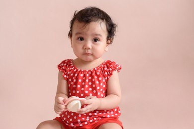 portrait of a sadly face cute little asian baby girl wear red dress siting and look at camera isolated on background, baby expression concept