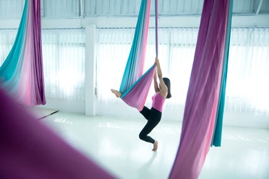 asian beautiful woman doing aerial dance practice in hammock at studio, asian women perform dances using a hammock in the dance