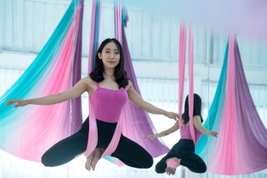 asian beautiful woman doing aerial dance practice in hammock at studio, asian women perform dances using a hammock in the dance