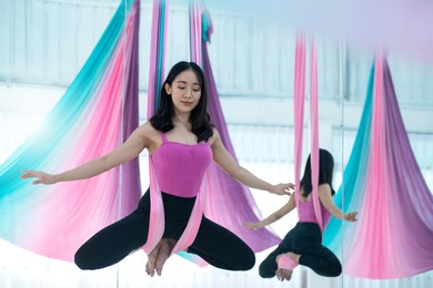 asian beautiful woman doing aerial dance practice in hammock at studio, asian women perform dances using a hammock in the dance