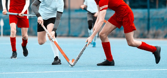 two field hockey player, fighting for the ball on the midfield during an intense match on green grass. professional sport concept. vintage color filter