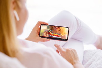woman watching cooking video on mobile phone