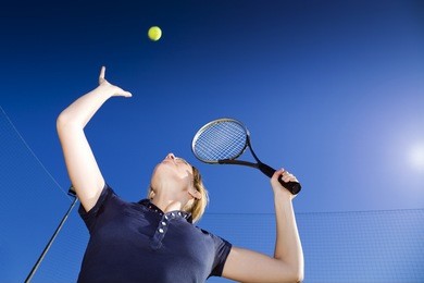 blond woman playing tennis, about to hit the ball. copy space