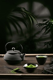 matcha tea powder and tea accessories on dark wooden base. tea ceremony. traditional japanese drink. vertical format.