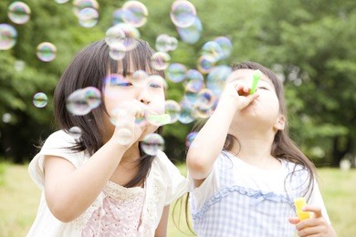 two girls playing with soap bubbles