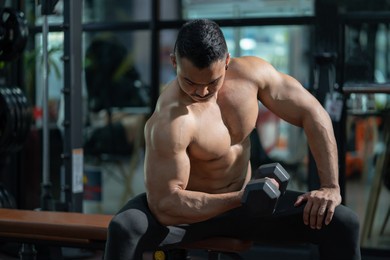 handsome shirtless adult asian men sweating while lift up the dumbbell workout for arm biceps muscle part inside of fitness gym. bodybuilding athlete sport training for body strength and good health.