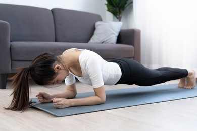 asian women exercise at home in the living room. health care women do plank to diet.