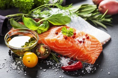 delicious  portion of fresh salmon fillet  with aromatic herbs, spices and vegetables - healthy food, diet or cooking concept