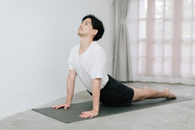 asian young man doing yoga at home