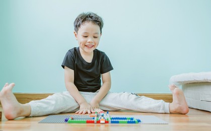 little boy playing and building with colorful plastic bricks. blocks of lego are sorted. early learning and development. soft focus.