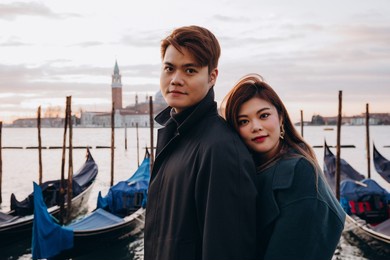 a romantic evening walk by a young asian couple at the pier. a young couple travels to venice.